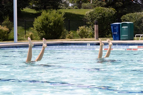 2 kids doing hand stands at the north pool